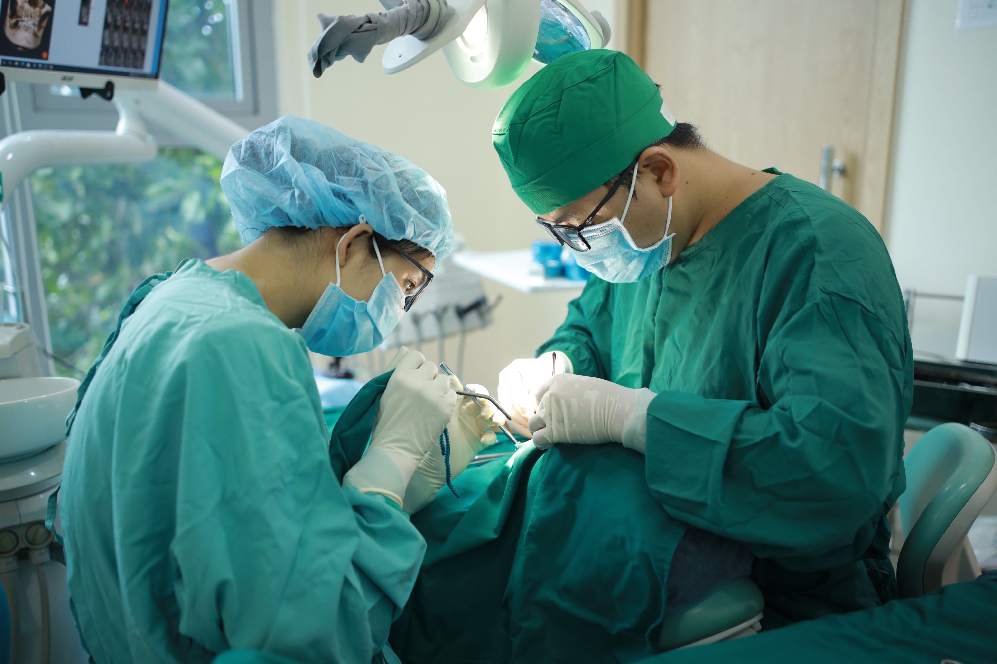 Thạc sĩ Bác sĩ Đoàn Vũ trong phòng phẫu thuật trồng răng Implant cho người trung niên mất răng tại nha khoa Dr. Care. 